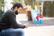 © Antonio Recena - Distracted father with the phone while son plays on the slide in playground