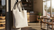 © emyillustrator - White canvas tote bag mockup hanging on a hook in a sunlit cafe, perfect for showcasing custom designs or branding