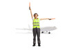 © Ljupco Smokovski - Woman aircraft marshaller signaling with wands in front of a plane