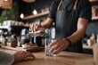 © Di Studio - Hands of a barista pouring  water in glass