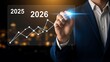 © Shabul - Businessman analyzing financial growth graph for 2025 and 2026 with a futuristic digital interface