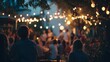 © Jojo* - People gather outdoors under strings of illuminated bulbs during twilight hours