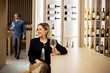 © BGStock72 - Woman enjoys a drink at a bar while a man walks in the background during a social event