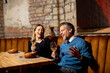 © BGStock72 - Friends enjoy drinks and laughter at a cozy restaurant in the evening