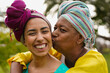 © Sabrina - Happy african mother kissing her daughter while wearing traditional dress and turban outdoor - Culture, family love and lifestyle concept