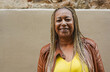 © Sabrina - Happy senior african woman with braided hair smiling on camera in the city - Joyful elderly person, travel and urban lifestyle concept - Copy space