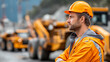 © Laura - Faceless industrial worker in orange safety gear standing near heavy machinery in mining operation, professional protective clothing, defocused equipment background, with copy spac