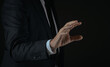 © Principe - Side view of businessman hand reaching to touch virtual interface on dark background
