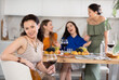 © JackF - Adult woman drinking wine in company of friends at home party in kitchen
