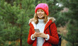 © rohappy - Happy smiling woman with phone, shopping bag in winter against Christmas tree, girl using smartphone