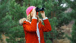 © rohappy - Woman tourist looking through binoculars watching nature, wild animals walking in winter forest