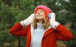 © rohappy - Happy young woman enjoy listening to music with headphones in winter forest against Christmas tree