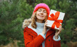 © rohappy - Happy smiling young woman holding red gift box on Christmas tree background in winter forest