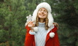 © rohappy - Winter day, happy smiling young woman enjoys snow, warm weather against Christmas tree background