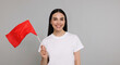 © New Africa - Happy woman with red flag on grey background. Banner design
