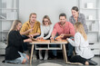 © Volodymyr - Group of friends eating pizza and laughing together. Happy friends enjoying pizza in a cozy room. Friendship and laughter make this meal special. Joyful group friends sharing tasty pizza.