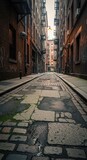 Narrow urban passage features uneven cobblestone and brick facades reaching toward a distant light source
