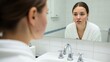 © Salman - Woman examining face in mirror with acne