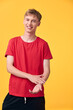 © SHOTPRIME STUDIO - Young man in a red t shirt smiles against a bright yellow background, casual fashion and lifestyle image for advertising, studio lighting, approachable and energetic vibe for campaigns