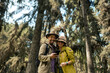 © Anthony Mujica Viera - A couple of tourists look at their phone happily in the middle of the forest. Travel concept