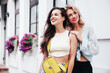 © halayalex - Two young beautiful smiling female in trendy summer clothes. Sexy carefree women posing in the street. Positive models having fun, hugging in sunny day. With bright makeup and red lips