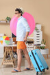 © Pixel-Shot - Young businessman with swim ring and suitcase waiting for summer vacation in office