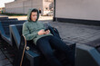 © Ljustina - Teenager relaxing on urban bench using smartphone