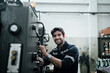 © KANGWANS - A man is fixing a machine with a watch on his wrist