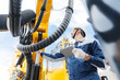 © Parilov - Mechanic inspecting hydraulic hoses of industrial geological drilling machine, mining equipment in garage service