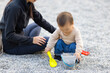 © leungchopan - Mother and baby enjoy playing dig stones