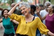 © Anna Lurye - Joyful senior Hispanic woman dancing salsa with friends outdoors for active lifestyle and social wellness concept