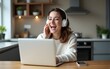 © Jacob - Attractive and happy middle age female freelancer is working at her home. She is using headphones, listening to music and singing. Modern kitchen in background. Freelancing job concept. High quality