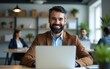 © Ethan - Modern Office: Portrait of Successful Middle Aged Bearded Businessman Working on a Laptop at his Desk. Smiling Corporate Worker. Multi-Ethnic Workplace with Happy Professionals. Front View Shot