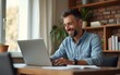 © Victoria - Portrait of Smiling Middle Aged Man Working from Home on a Laptop Computer in Sunny Cozy Apartment. Successful Male Entrepreneur Does Remote for e-Business Project, Online Shopping. High quality
