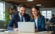 © Owen - Professional business people, two happy business man and woman executives partners team working together checking corporate results standing in company office using laptop looking at camera. Portrait