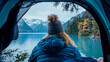 © sommersby - View from inside cozy tent looking out at woman in puffy jacket enjoying tranquil scene of turquoise mountain lake and imposing snowy peaks.