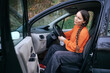 © ADDICTIVE STOCK - Young woman sitting in a car, ready to start the journey