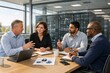 © imagemir - A diverse group of professionals engaged in a cybersecurity discussion in a modern office setting, showcasing teamwork and collaboration.