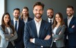 © Mia - Diverse group of business people team standing in an office, smiling and looking at the camera with arms crossed. A man posing as the leader is in the center posing for a portrait. High quality