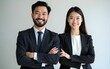 © Sadie - Portrait shot of two happy Asian professional successful bearded male businessman in formal business suit and female colleague businesswoman standing crossed arms smiling look at camera together.
