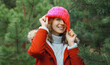© rohappy - Winter portrait of happy cheerful woman having fun in hat against Christmas tree in forest
