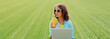 © rohappy - Woman drinking juice with laptop in the park on green grass background