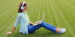 © rohappy - Happy young woman with laptop listening to music in headphones in summer park