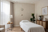 Wellness room with a massage table, plants, and soft natural light during the day