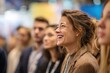 © Iftikhar alam - Happy staff enjoying a lively event while engaging with speakers at a bustling conference in a vibrant exhibition hall