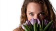 © Pinklife - A close-up of a woman holding a bouquet of lavender tulips close to her face, capturing a moment of beauty and connection with nature in a bright and airy environment.