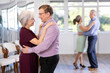 © JackF - Middle-aged man paired senior woman and leisurely dancing slow dance in studio for beginners learning pair dancing. Woman clung to her partner, put her head on mans shoulder