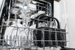 © wedmoments.stock - Dishwasher loaded with clean glassware and utensils, showcasing organized interior with plates and cutlery, emphasizing modern kitchen appliance efficiency and functionality