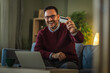 © Miljan Živković - Happy man holding credit card shopping online
