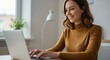 © Image - Woman smiling while typing on a laptop in a brightly lit room with a warm, positive aura.